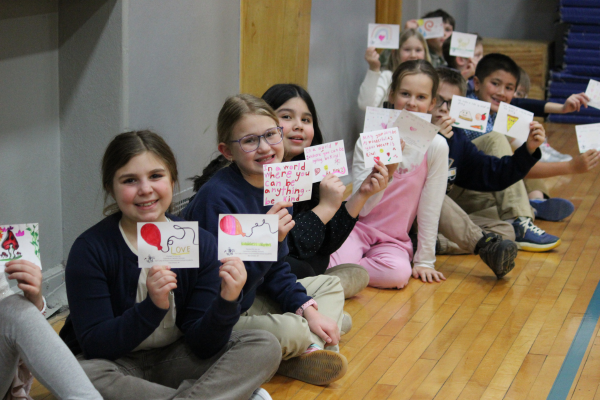 Our Lady of Peace Intermediate students holding kindness cards for NOW bags they filled during Lent.
