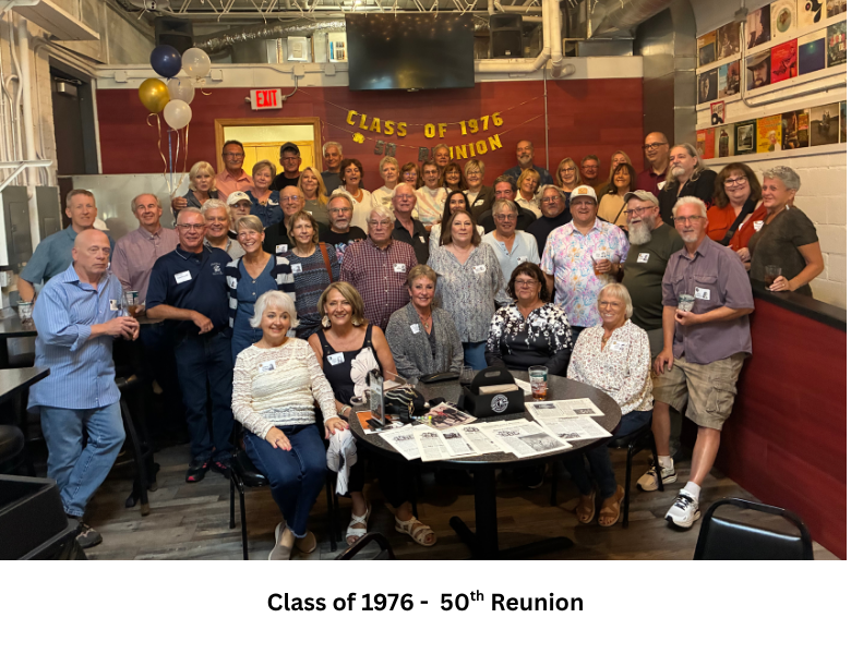 Members of the Columbus Catholic Class of 1976 gather for a group photo beneath a 50th banner.